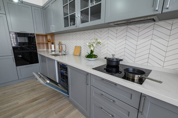 Moderno mobiliário de cozinha moderna cinzenta e branca da moda com fornos porta aberta - Foto, Imagem