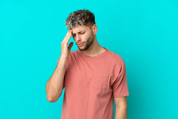Young handsome caucasian man isolated on blue background with headache - Fotografie, Obrázek