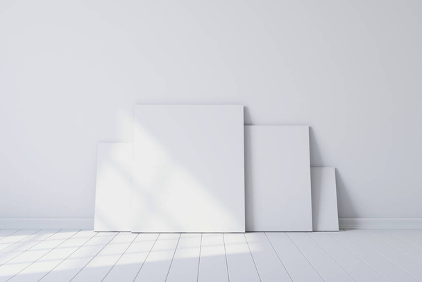 Blank canvases of paintings in an empty white room. 3d rendering - Zdjęcie, obraz