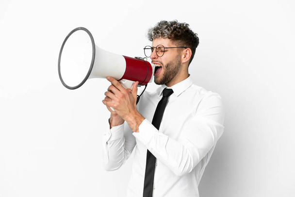 Business caucasian man isolated on white background shouting through a megaphone - Foto, imagen