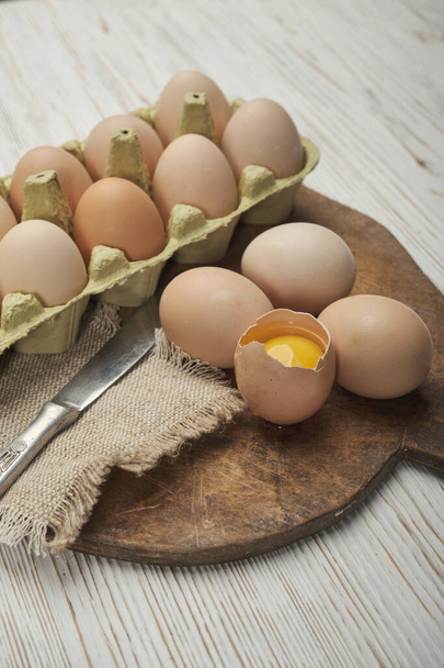 Крупный план сырых куриных яиц в яичной коробке на деревянном фоне. Сырые куриные яйца в яичной коробке органические продукты питания для хорошего здоровья высокий белок . - Фото, изображение