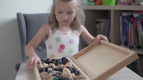 Маленька дівчинка відкриває шахівницю і досягає дерев'яних фігур
 - Кадри, відео