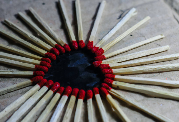 Matchstick con una cabeza roja en forma de corazón sobre un fondo de madera. Matchstick arte fotografía.  - Foto, imagen