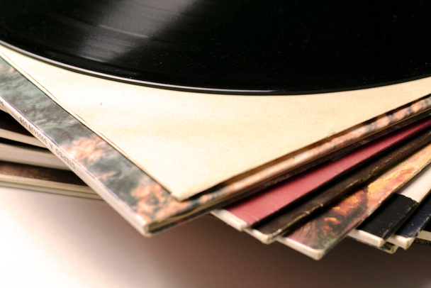una pila di vecchi dischi in vinile da vicino uno dei dischi viene estratto dalla busta - Foto, immagini