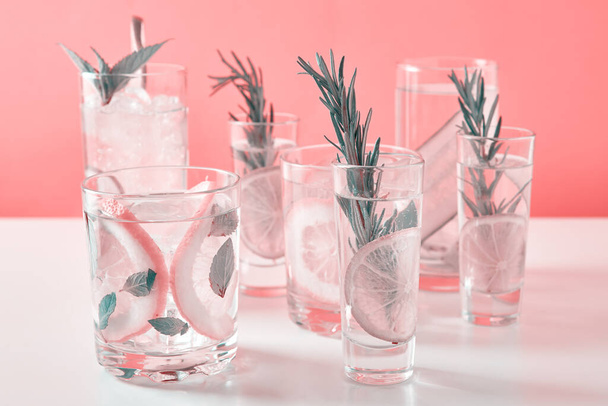 Drink with lime and rosemary on pink background - Foto, afbeelding
