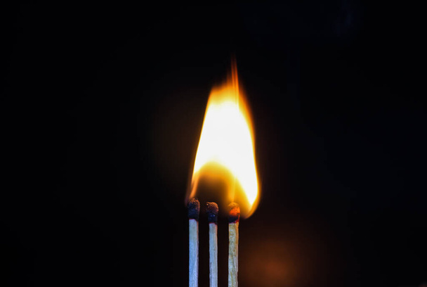 Groep van een rode lucifer branden geïsoleerd met de achtergrond. Rij brandende lucifer in de kettingreactie. Matchstick art fotografie. - Foto, afbeelding