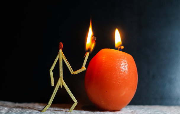 Matchsticks in form of a man lighting a candle, matchstick man lighting a candle. Matchstick art photography used matchsticks to create the character. - Photo, Image