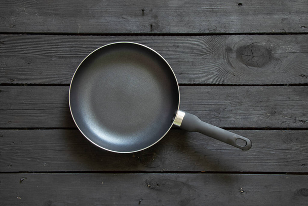 new black non-stick skillet on black wooden table, skillet on table - Photo, Image