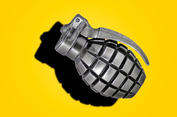 Encendedor de granada aislado con sombra dura sobre fondo amarillo - Foto, Imagen