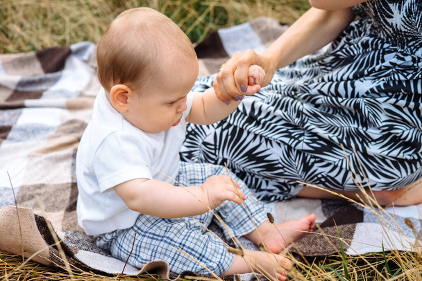 Infant baby boy sitting up outdoors on the blanket - Fotografie, Obrázek