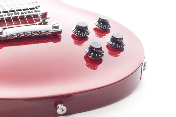 Detailní záběr červené elektrické kytary s tlačítky a strunami na bílém pozadí - Fotografie, Obrázek