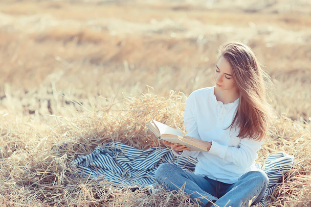 female reading a book in a field summer straw woman reading a book student studying summer vacation from school girl in the field - Photo, Image