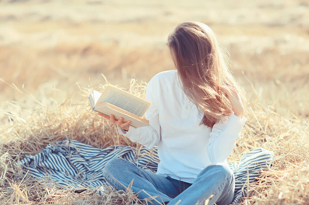 fêmea lendo um livro em um campo de verão mulher palha lendo um livro estudante estudando férias de verão da menina da escola no campo - Foto, Imagem