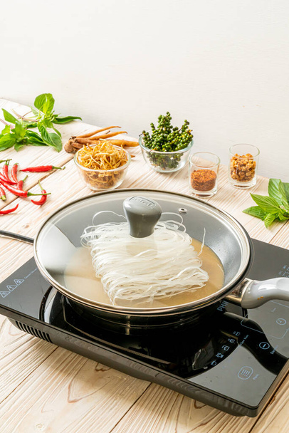 putting noodle on pan with sauce ready to stir fried - Valokuva, kuva