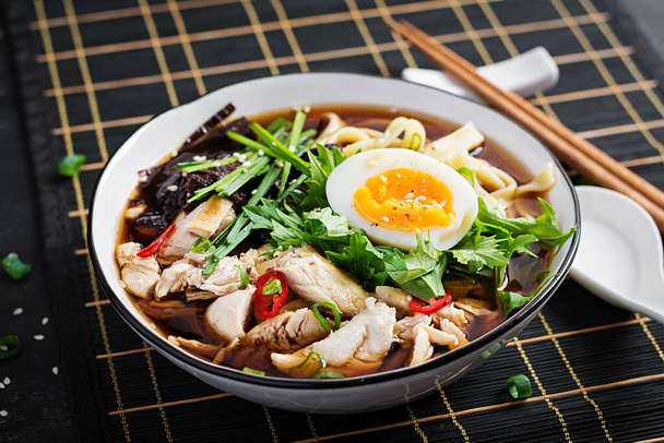 Sopa de miso. Sopa de ramen japonés con pollo, huevo, nori y nipposinica sobre fondo oscuro. - Foto, Imagen