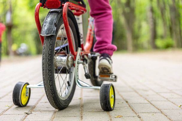 Primo piano di un bambino in bicicletta con tre ruote. - Foto, immagini