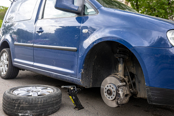 Auto senza ruota e sollevare da idraulico, in attesa di sostituzione pneumatici. - Foto, immagini