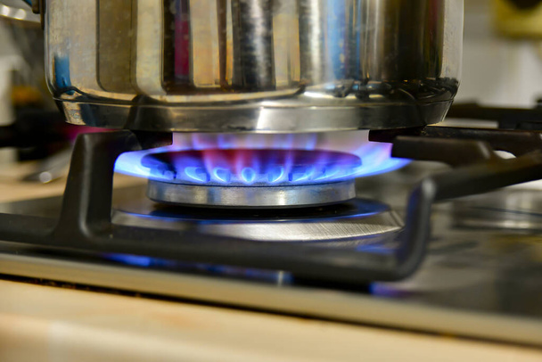 Θέρμανση του νερού σε ένα βραστήρα σε ένα φούρνο αερίου στο σπίτι. - Φωτογραφία, εικόνα
