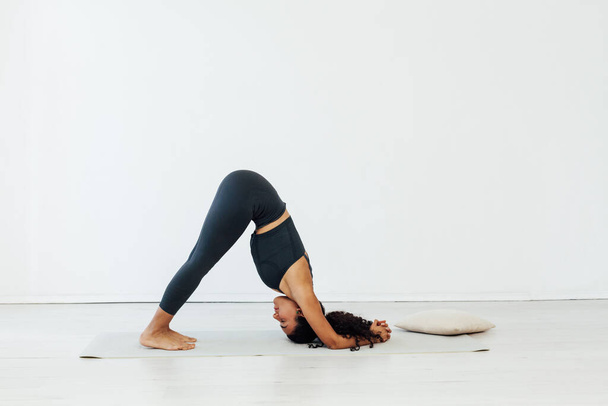 Beautiful brunette woman engaged in yoga asana gymnastics flexibility - Photo, Image