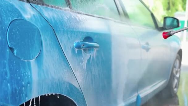 Samochód czyszczący z wodą wysokociśnieniową na stacji myjni samochodowej - Materiał filmowy, wideo