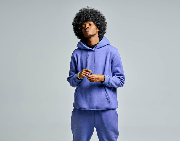 Handsome black man in blue set of tracksuit with afro hair - Foto, Imagen
