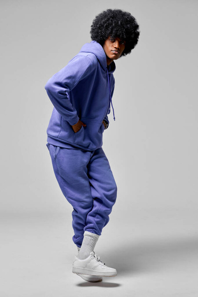 Young black man dancing in blue set of tracksuit isolated on gray background - Fotografie, Obrázek