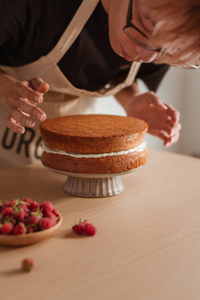 Шеф-кухар випічки кладе шар торта на торт. Створення процесу торта
 - Фото, зображення