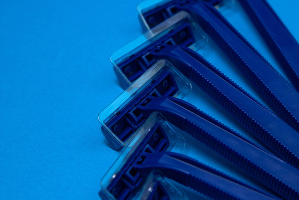 Men's razors on a blue background. Disposable men's razor close-up. - Foto, Imagem