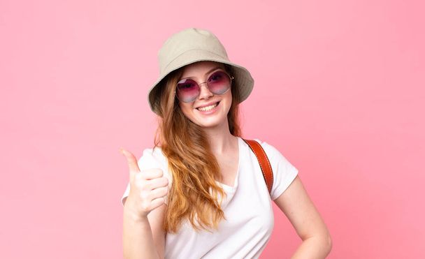 red head pretty woman tourist feeling proud,smiling positively with thumbs up - Foto, Bild