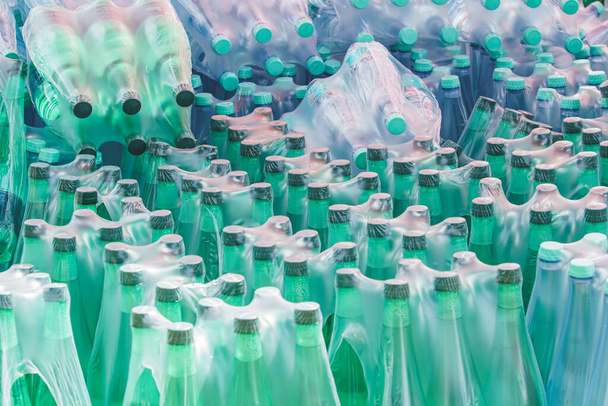 Πλαστικές φιάλες νερού τυλιγμένες σε πλαστική μεμβράνη - Φωτογραφία, εικόνα