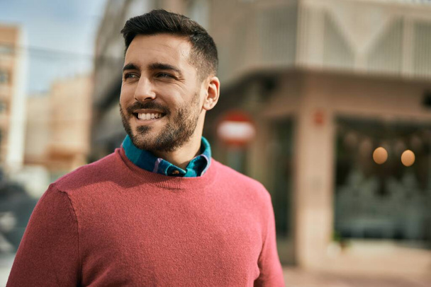Genç İspanyol adam gülümseyerek şehirde mutlu mesut dikiliyor.. - Fotoğraf, Görsel