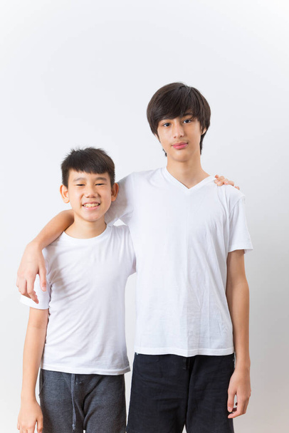 Two boy kid in white t-shirt standing isolated on a white background. - Foto, immagini