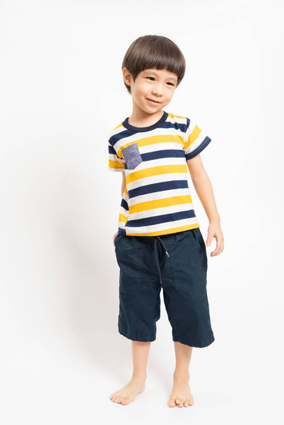 Aranyos mosolygós ázsiai fiú gyermek visel csíkos ing áll elszigetelt felett fehér háttér. - Fotó, kép