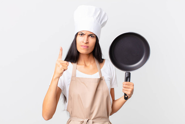 hispanic pretty chef woman holding a pan - Foto, Imagen