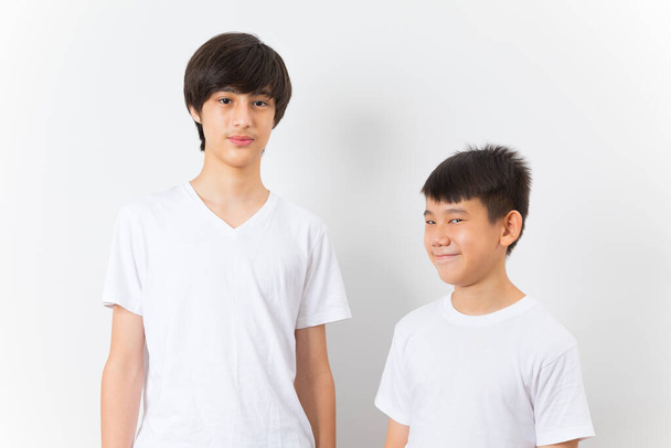 Deux garçons en t-shirt blanc debout isolé sur un fond blanc. - Photo, image