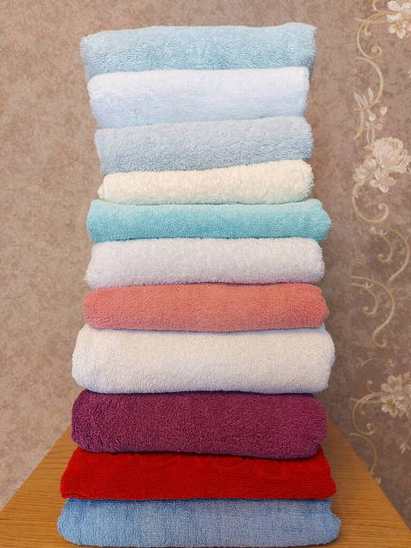 Многоцветные хлопчатобумажные махровые полотенца укладываются - Фото, изображение