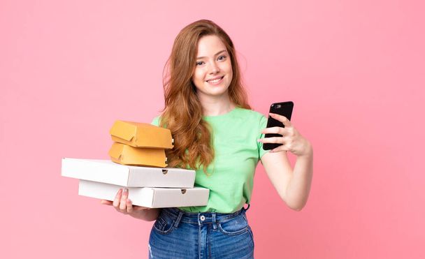 pretty red head woman holding take away fast food boxes - Foto, Imagem