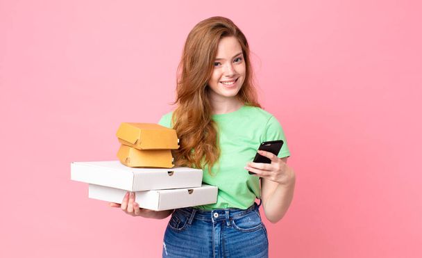 pretty red head woman holding take away fast food boxes - Foto, imagen