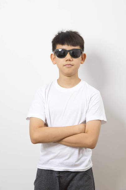 Portrait of handsome Asian boy with sunglasses on white background. - Photo, Image