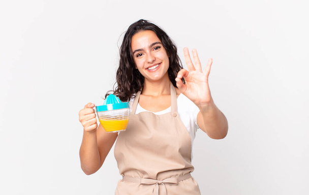 hispanic pretty chef woman preparing an orange juice - Photo, image