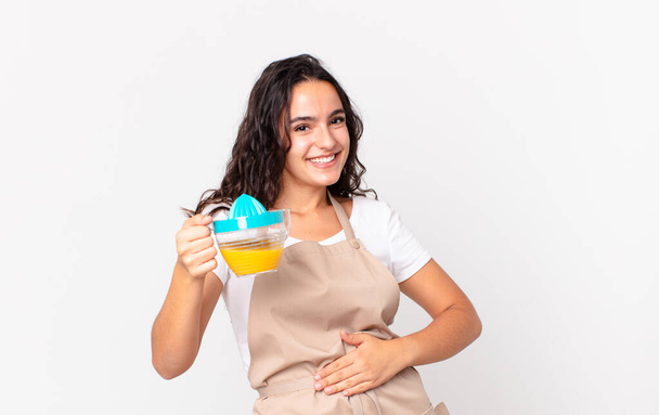 hispanic pretty chef woman preparing an orange juice - Photo, Image