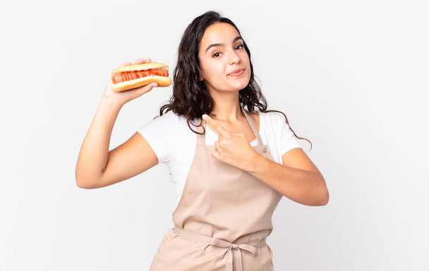 hispanic pretty chef woman holding a hot dog - Valokuva, kuva