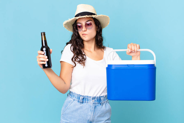 hispanic pretty woman with a portable fridge and a beer bottle - Photo, Image