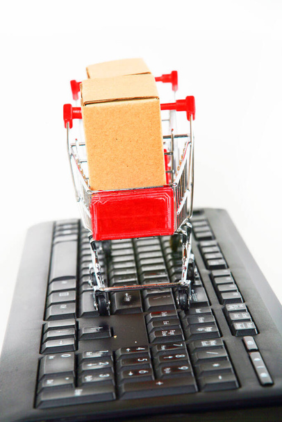 nákupní vozíky s krabicemi na počítačové klávesnici bílé pozadí  - Fotografie, Obrázek