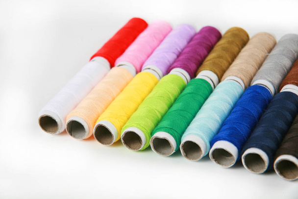 Цветные нити для шитья на белом фоне
  - Фото, изображение