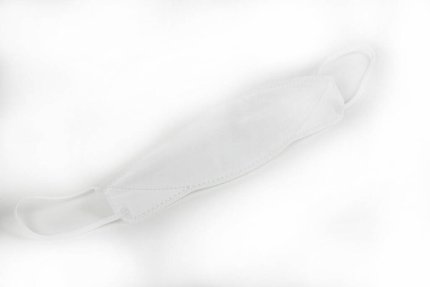 white disposable mask on a light background  - Foto, Bild