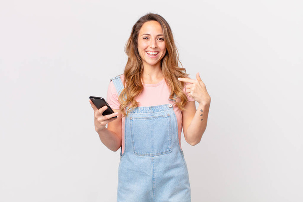 pretty woman feeling happy and pointing to self with an excited and holding a smartphone - Photo, image