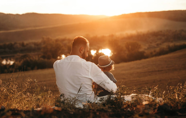 Father and kid enjoying sunset in nature - Photo, image