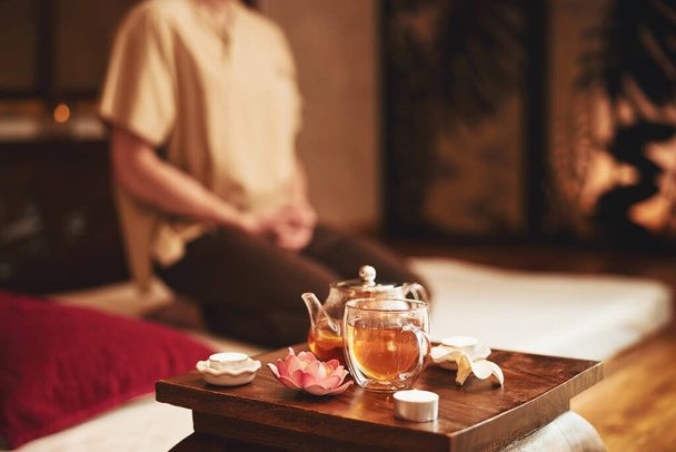 Man doing meditation during tea ceremony indoors - Фото, зображення