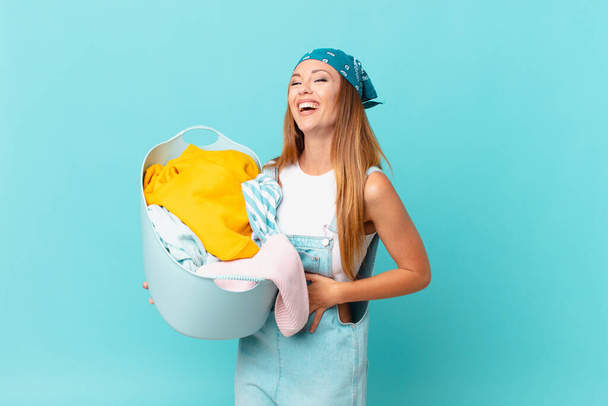 pretty woman laughing out loud at some hilarious joke holding a wash basket - Fotó, kép
